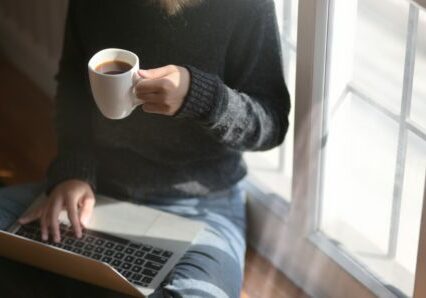 vrouw met laptop en koffie